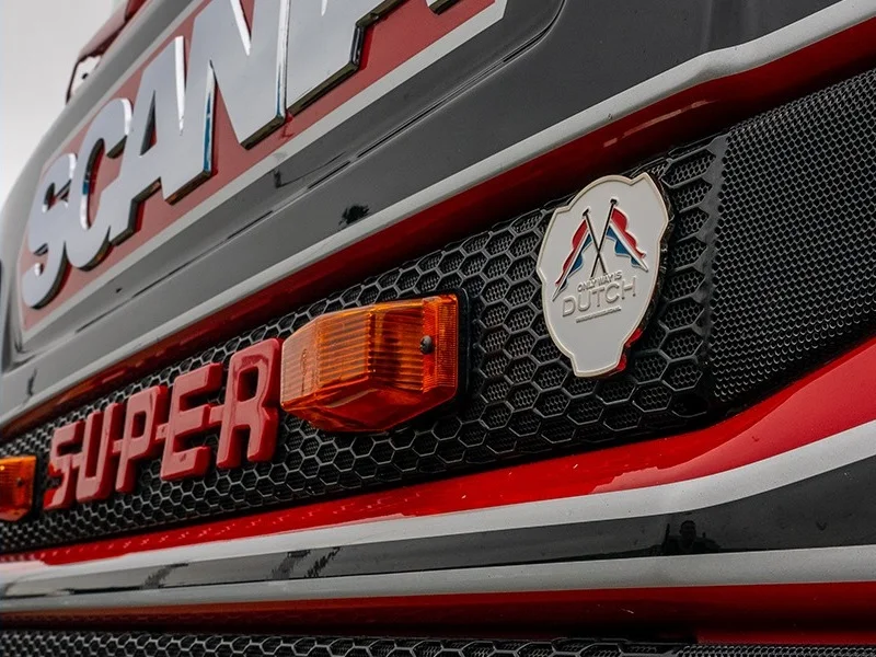 Doppelbrenner mit orangefarbenem Glas am Kühlergrill eines Scania mit dem niederländischen Emblem von Only Way